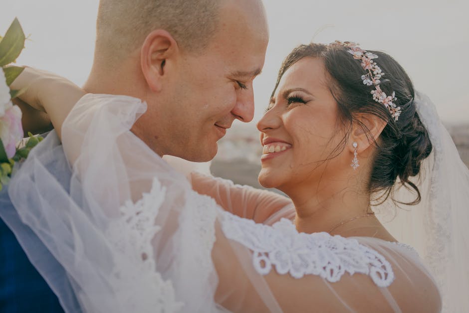 A happy couple embraces and smiles during their wedding day celebration.